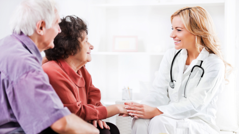 Female Doctor talking to Elderly Couple