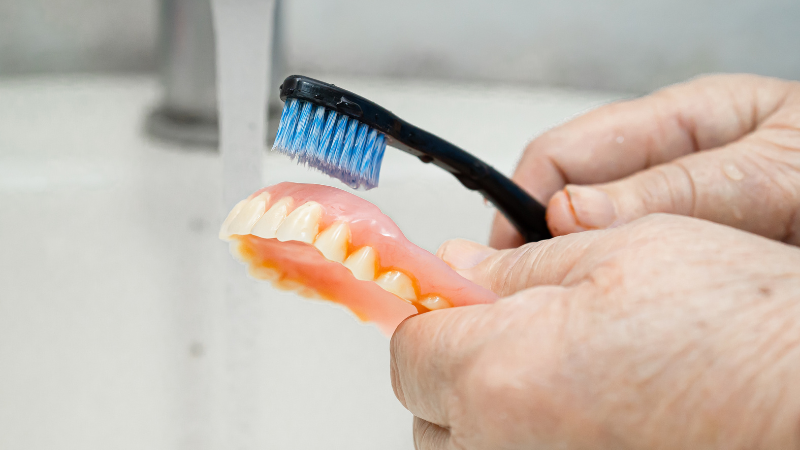 Dental Implants vs Dentures - Denture brushing