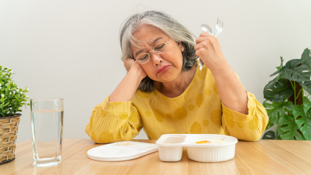 Senior woman at table but not interested in food