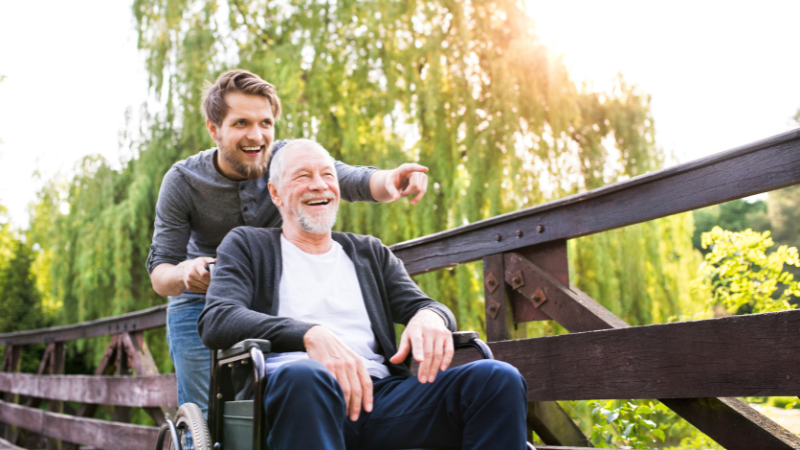 How to Choose the Best Wheelchair for Elderly Seniors - Adult son pushing dad in wheelchair