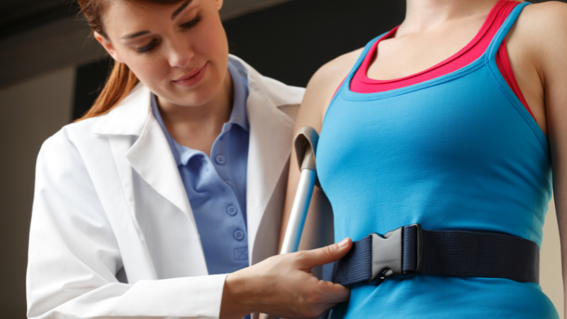 How to Use a Lift Belt for Elderly: Physical Therapist fitting a gait belt on female patient.
