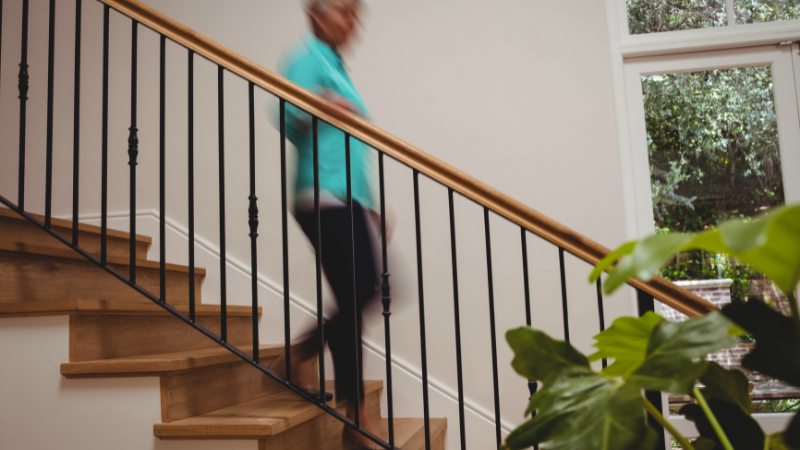 Stair Safety For Seniors - Woman holding hand rails going downstairs